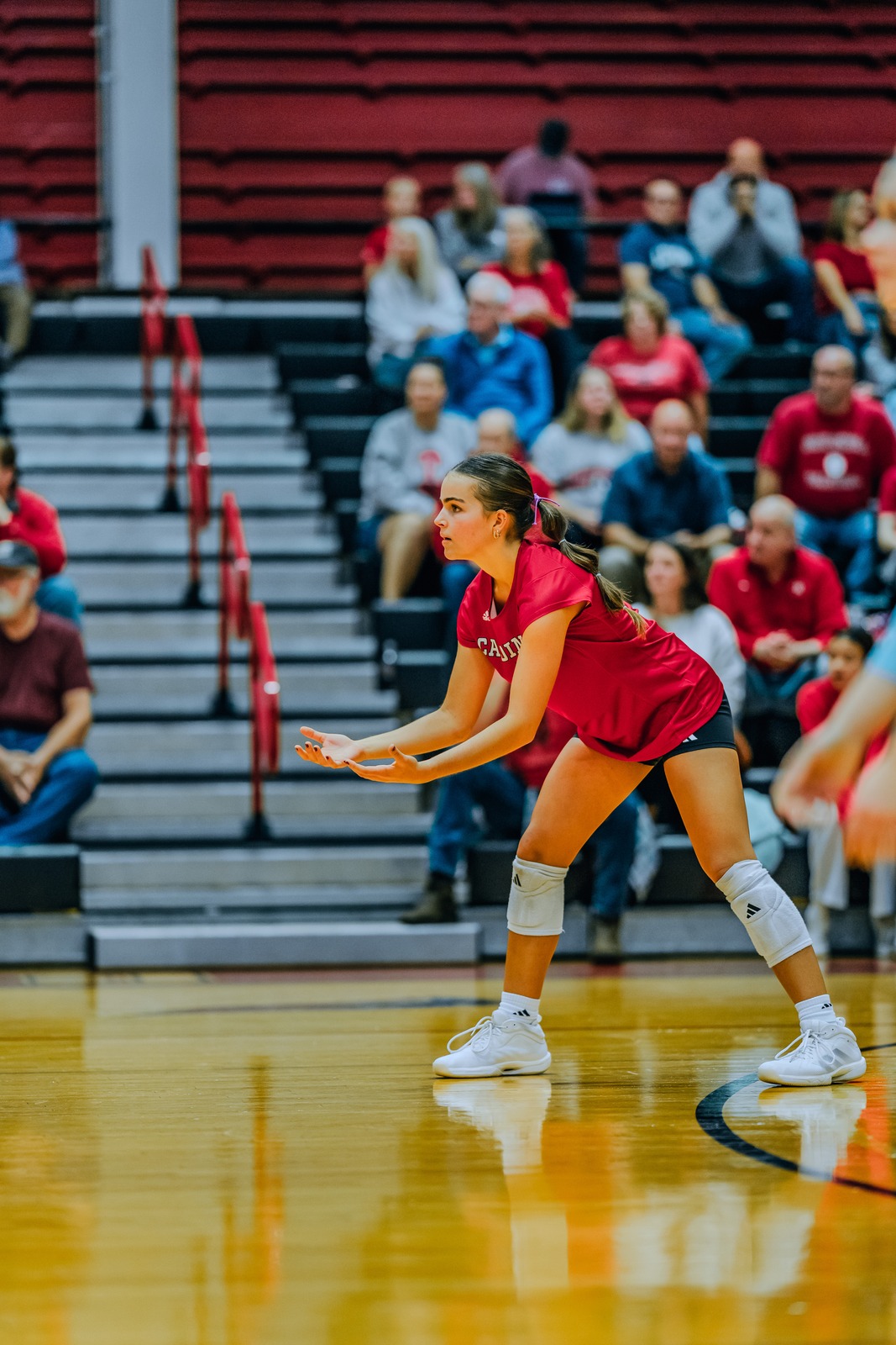 A player in red crouches with hands extended forward.