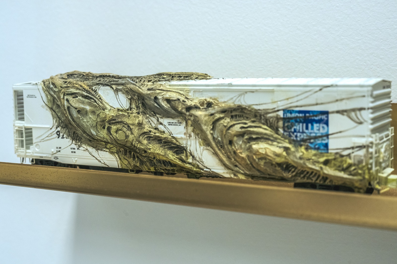 A model train car with a textured, organic material covering it.