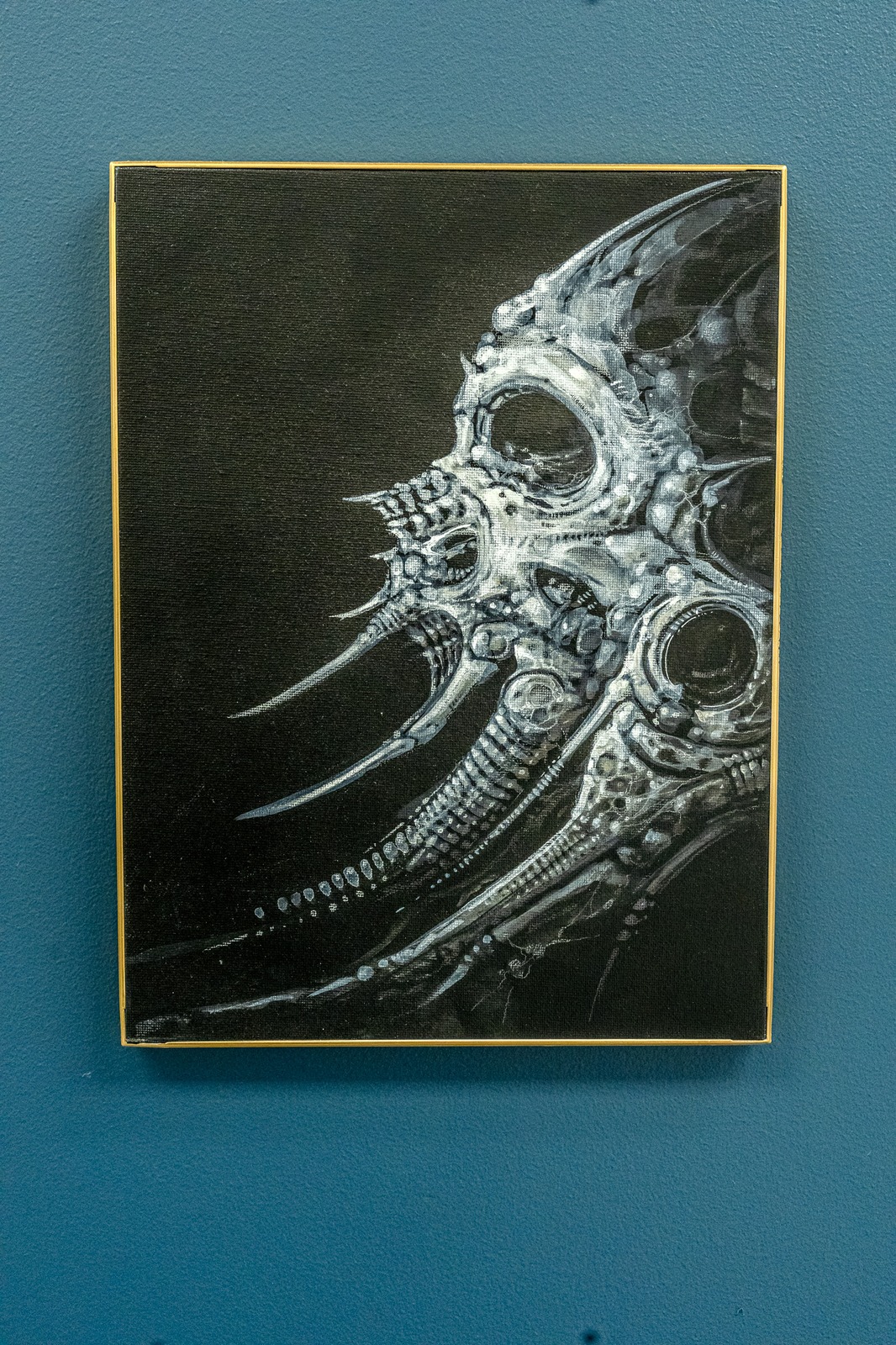 A painting of a biomechanical creature's head.