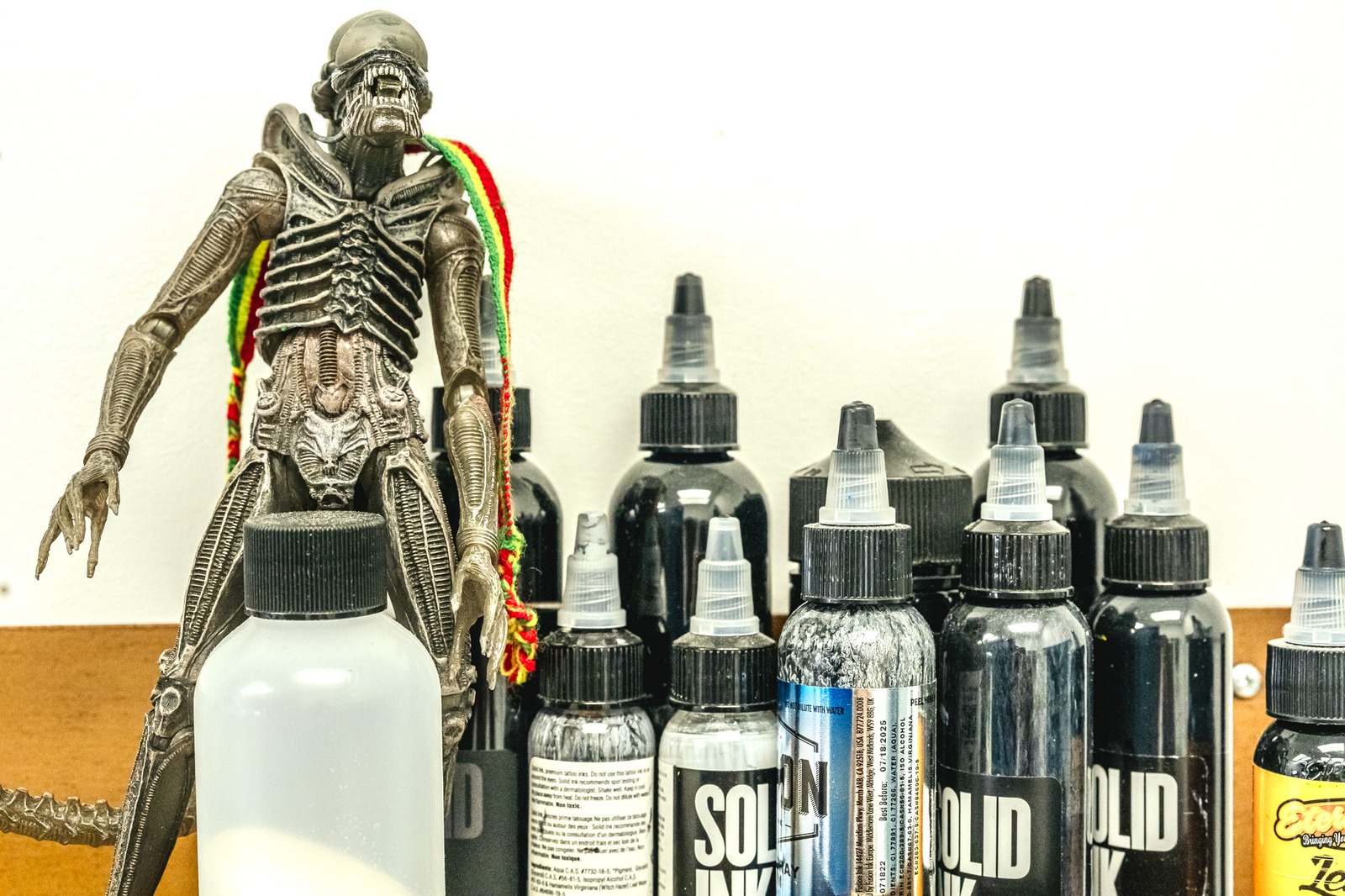 A detailed action figure stands with bottles.