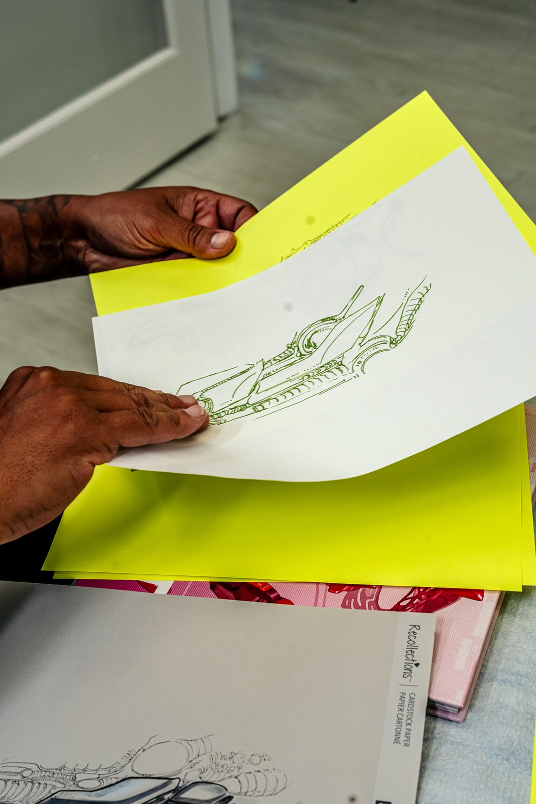 A person in a black top holds a drawing.