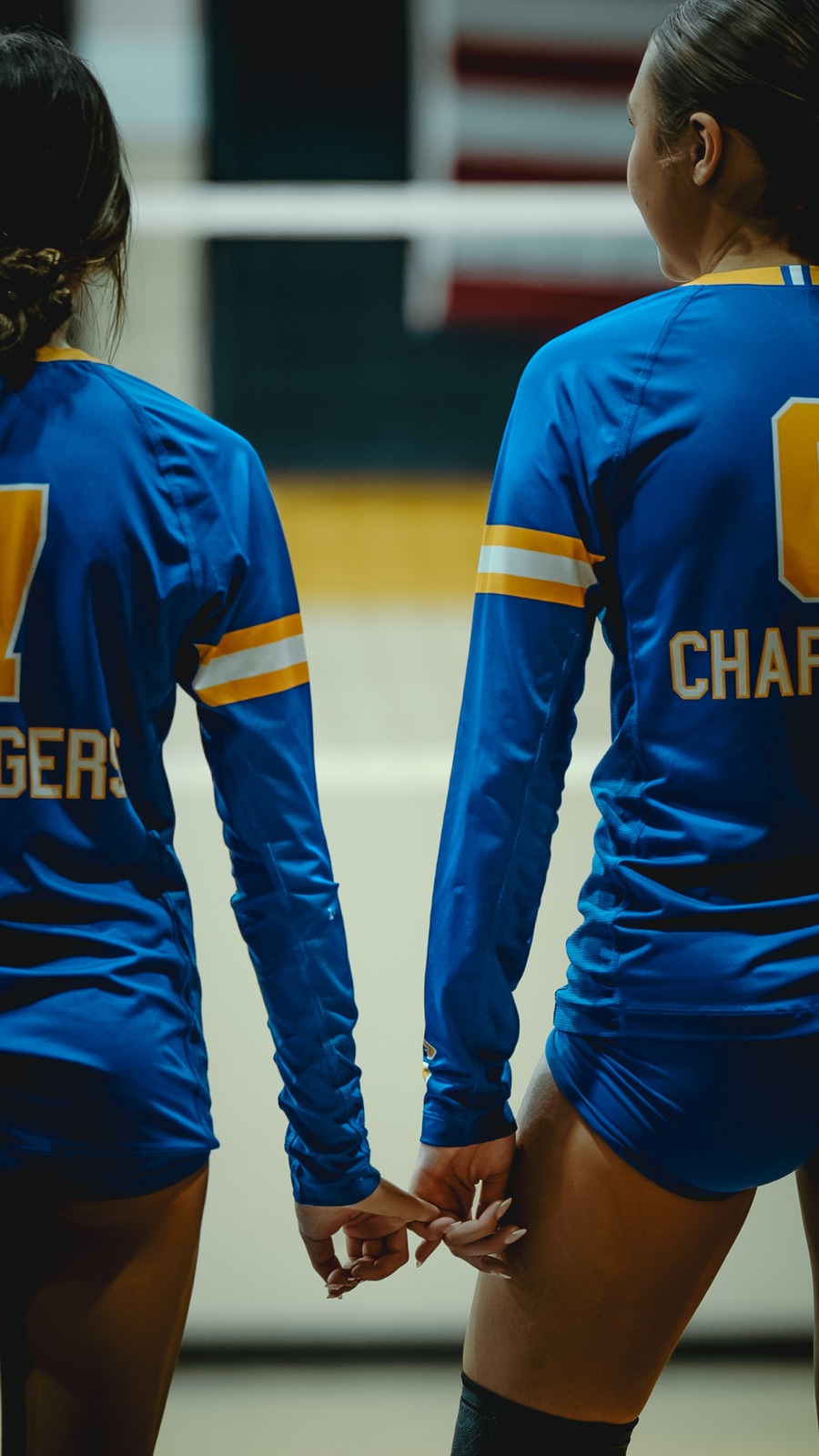 Two players in blue uniforms hold hands.