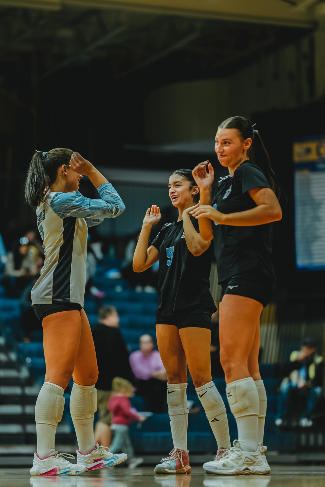 A player in black and a player in black and white high five.