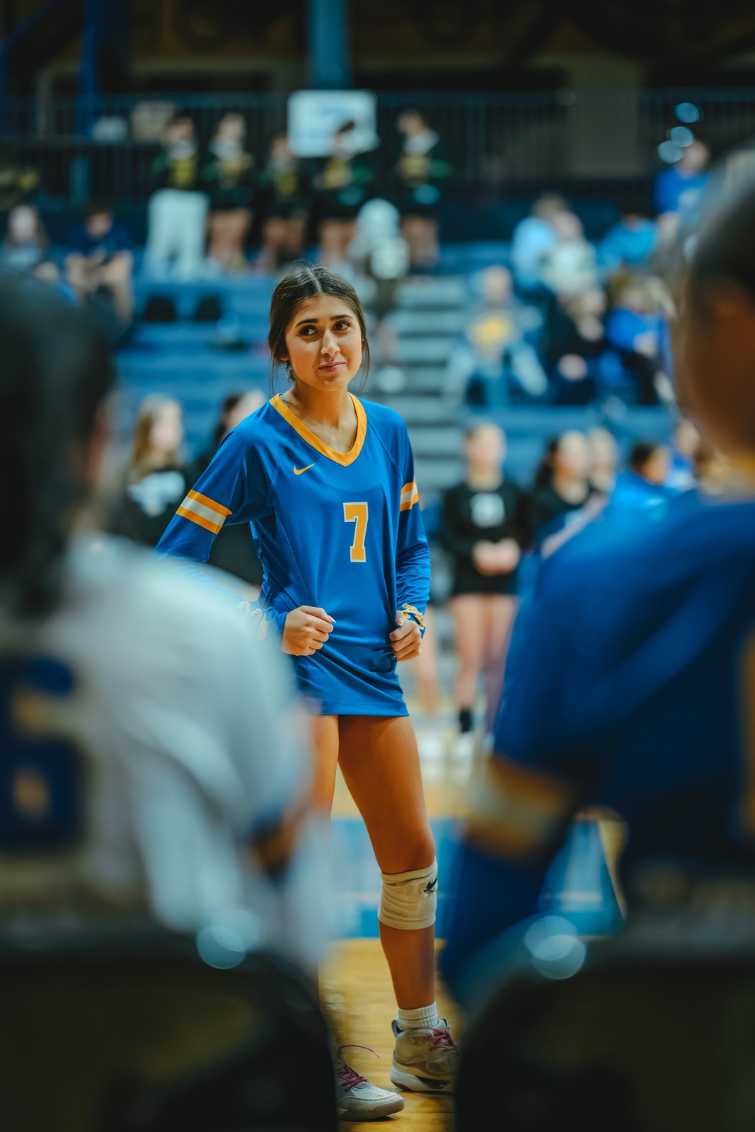 A player in a blue uniform stands with hands on hips.