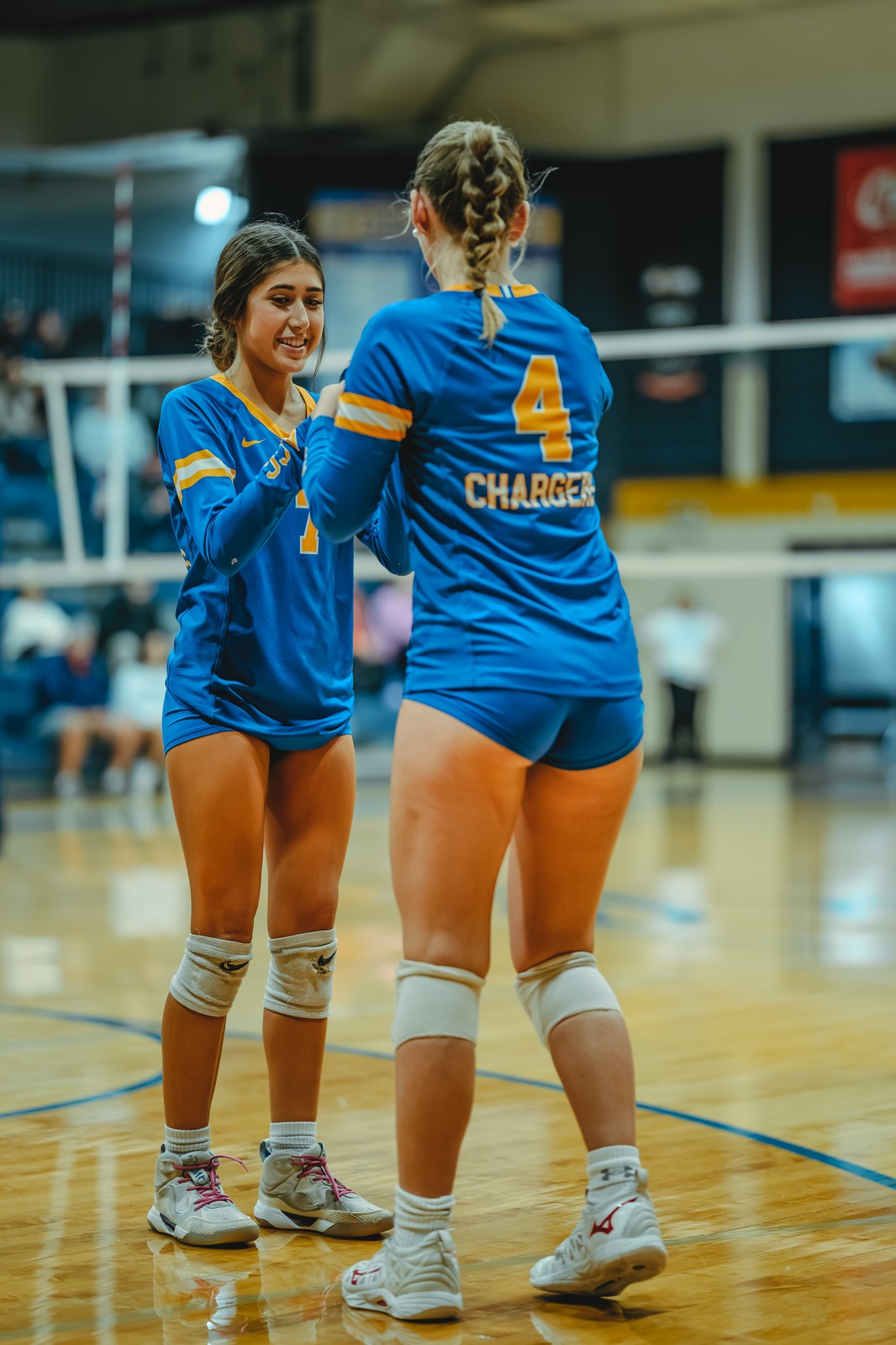 A player in blue smiles and reaches toward another player in blue.