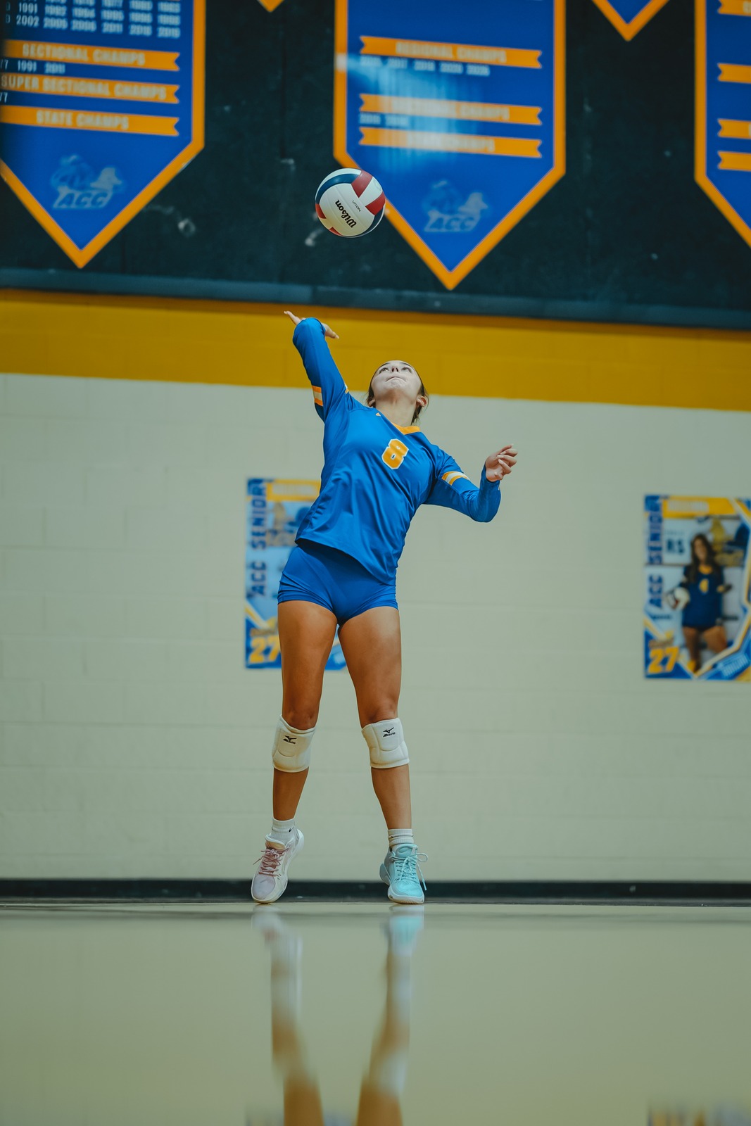 A player in a blue uniform jumps and reaches for the ball.