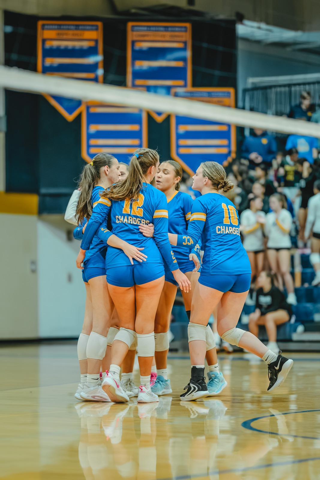 Players in blue uniforms huddle together on a court.