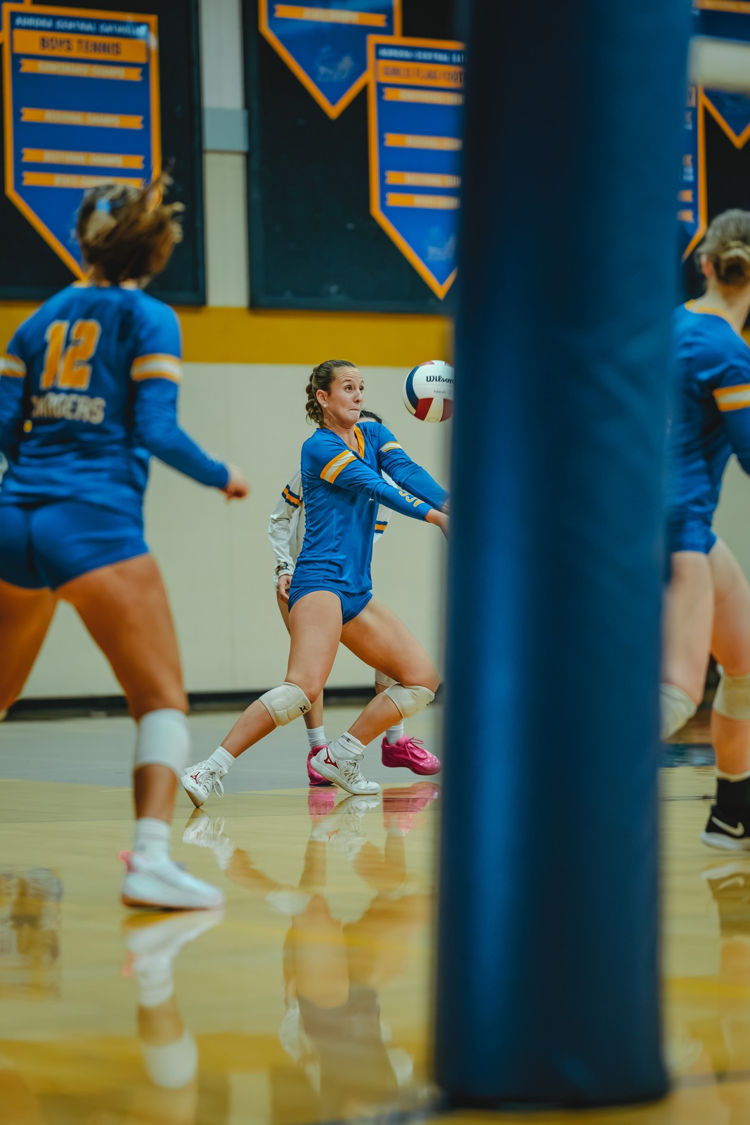 A player in a blue uniform reaches low for the ball.
