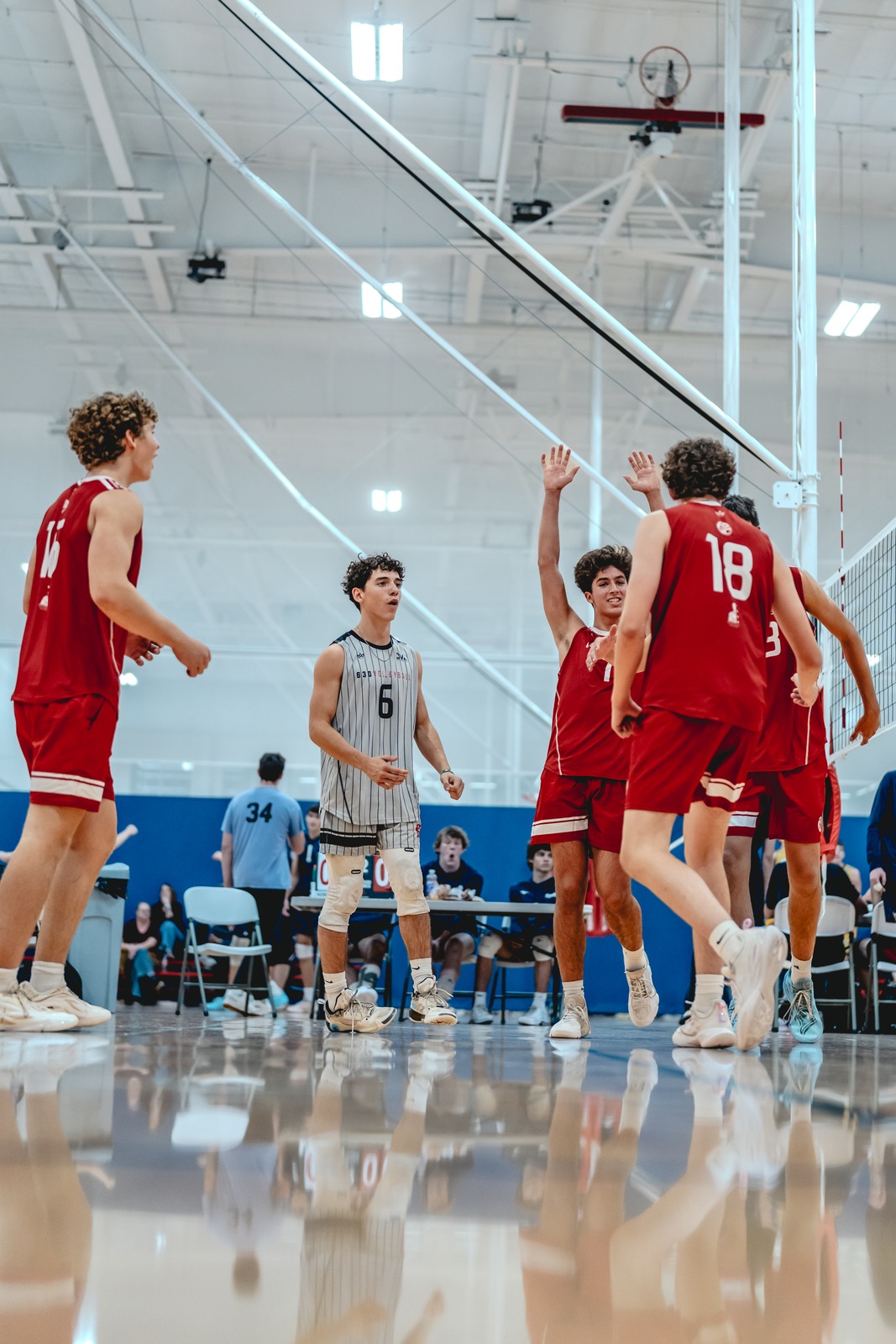 Players in red and gray uniforms interact on a court.